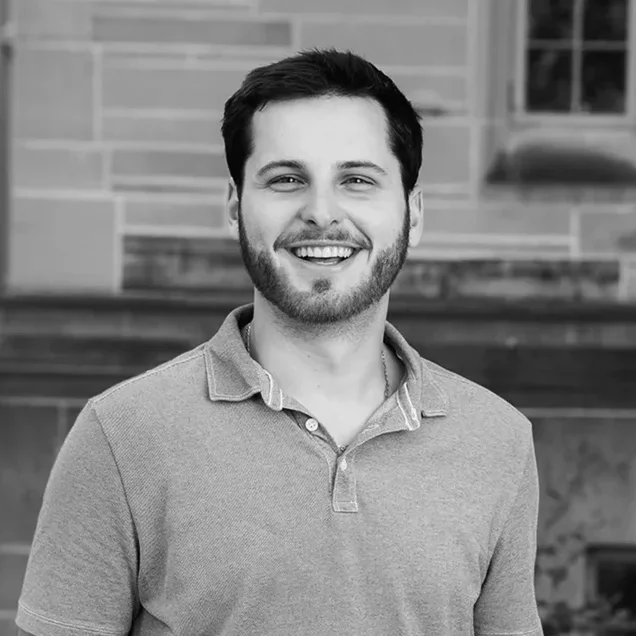 Charlie Brizz, smiling, in front of a limestone building